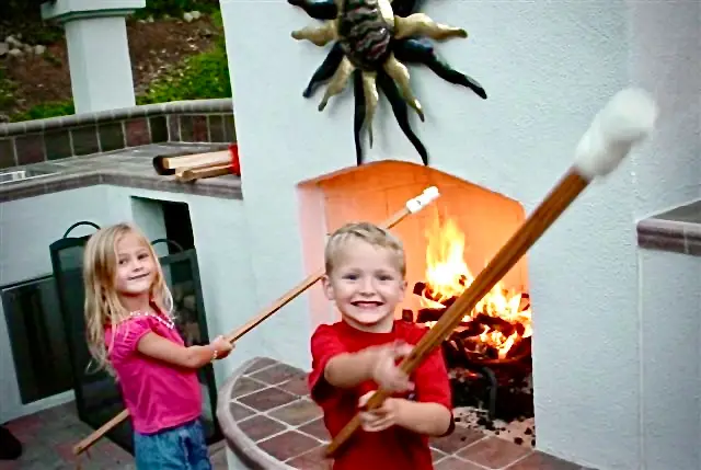 ids roasting marshmallows in front of a fireplace.